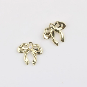 Macro-opname van twee gouden strikhangers met parel en oogje voor DIY-sieraden maken