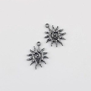Macro view of vintage style alloy sun charms with spiral patterns for jewelry making