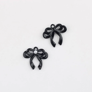 Detail van zwarte strikbedeltjes met parel en ophangringen voor doe-het-zelf sieraden