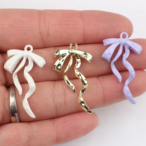 Drei minimalistische Schleifenanhänger in Weiß, Gold und Lavendel für DIY-Schmuckherstellung