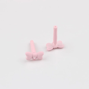 Detailed view of matte pink bow-shaped earring charms with pins for DIY jewelry making