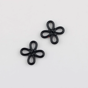 Close-up of a glossy black alloy Chinese knot pendant for DIY jewelry making