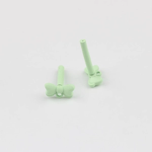 Close-up of light green matte bow charms with stainless steel pins for DIY earring making