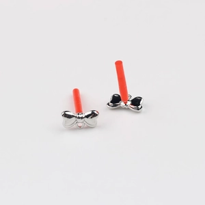 Detailed view of silver bow-shaped earring charms with red protective tubes for DIY
