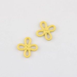 Macro detail of matte yellow flower pendants with traditional Chinese knot style design