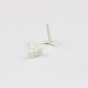 Detail of cream white bow earring charms with matte finish and loop for DIY jewelry