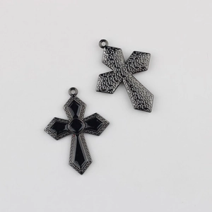 Détail du pendentif croix en alliage avec émail noir et motif d'étoiles sur le revers