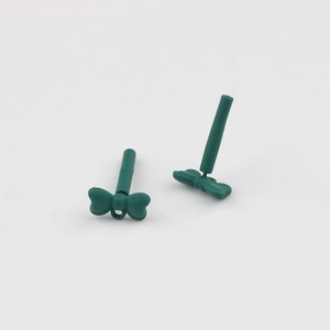 Macro detail of dark green matte alloy bow earrings with stainless steel pins