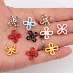 Hand holding colorful alloy knot pendants for DIY bracelets and necklaces jewelry making