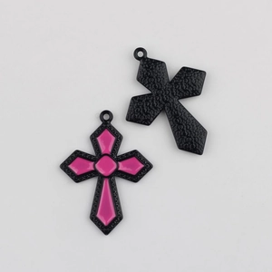 Détail d'un pendentif croix en émail rose avec cadre en métal noir et texture