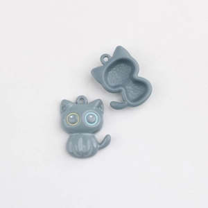 Détails macro de pendentifs chat en alliage montrant l'avant lisse et l'arrière étoilé