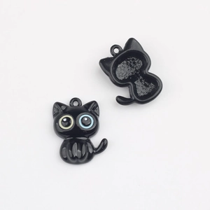 Détail du pendentif chat montrant l'avant avec yeux vairons et l'arrière avec motifs d'étoiles