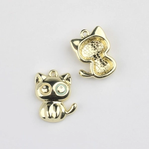 Détail macro du pendentif chat doré avec yeux en émail et texture nid d'abeille au dos