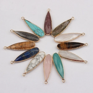 Macro detail of 12 teardrop-shaped natural stone pendants with gold plated edging frames