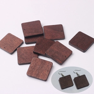 Macro shot of 27mm square walnut wood beads with pre-drilled holes for DIY jewelry