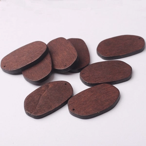 Macro view of walnut color oval wooden pendants with natural wood grain for DIY jewelry