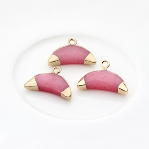 Vue détaillée de trois pendentifs demi-lune en agate rose avec bordure en métal doré