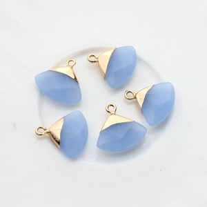 Set di cinque ciondoli in agata blu cielo a ventaglio con bordi dorati su piatto ceramico