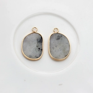 Macro shot of irregular grey agate pendants with gold plated edges for DIY jewelry making