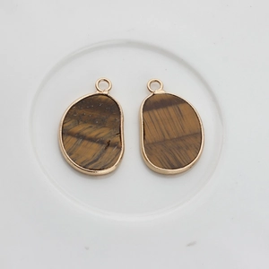 Detail view of irregular brown agate stone pendants with gold-plated metal edging