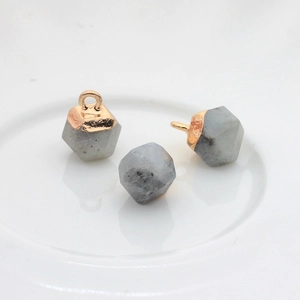 Macro-detail van zeshoekige natuurstenen met vergulde kapjes voor DIY-sieraden maken