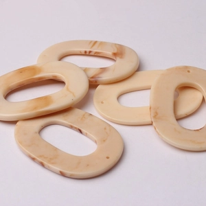 Five oval resin pendants with amber marble texture and dual holes for DIY jewelry