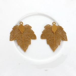 Detail of hollow maple leaf copper pendants with intricate mesh vein structure for DIY jewelry
