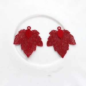 Detail of red hollow maple leaf pendants with intricate mesh veins for DIY jewelry