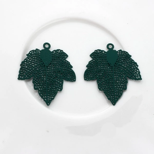 Close-up of dark green maple leaf charms with detailed hollow veins for DIY jewelry