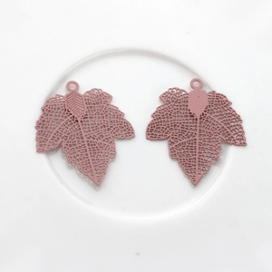 Detailed view of matte red maple leaf hollow copper pendants for DIY earring jewelry making