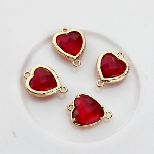 Detailed view of four red heart-shaped crystal pendants with gold plated copper borders