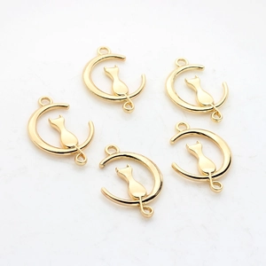 Five golden cat on moon alloy charms for jewelry making on a light textured stone surface