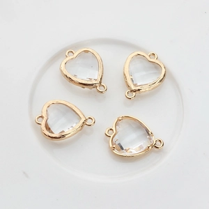 Macro shot of four golden heart-shaped crystal connectors with double hanging loops