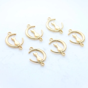 Macro detail of six golden alloy cat on moon pendants for DIY jewelry making