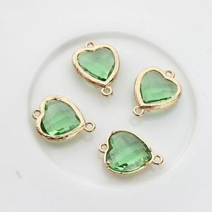 Detail view of 13x18mm green heart crystal pendants with gold frames and double loops