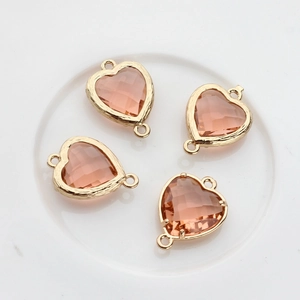 Detailed view of four peach heart crystal pendants with gold double-ring connectors
