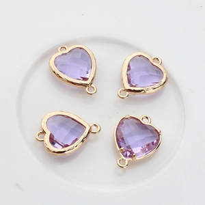 Macro view of light purple heart crystal pendants with gold-plated metal frames