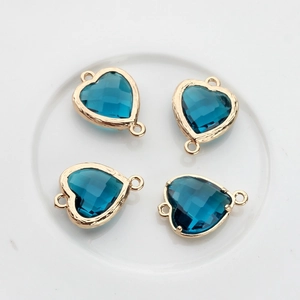 Macro shot of 13x18mm heart-shaped blue crystal pendants with double-sided facets and gold edges