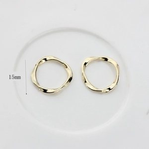 Detail view of 15mm golden irregular wavy textured round metal pendants for DIY jewelry