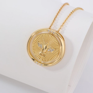 Détail macro du collier pendentif rotatif en or avec motif d'oiseau et oxydes de zirconium