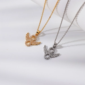 Detail of angel wing pendant necklaces with sparkling rhinestones in gold and silver finish