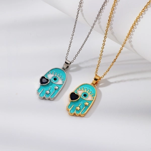 Detailed close-up of gold and silver Hamsa pendants with turquoise enamel and evil eye