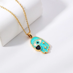 Golden Hamsa necklace with turquoise enamel, evil eye charm and heart gemstone detail