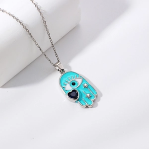 Hamsa hand necklace with blue enamel, evil eye, and heart stone on a silver chain