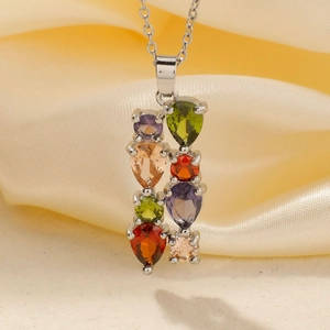 Close-up of multicolor AAA zircon pendant necklace with pear-cut stones on silk fabric