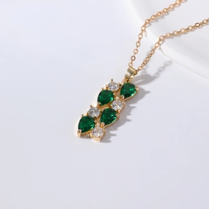 Elegant gold chain necklace featuring green pear-cut stones and white zircon crystals