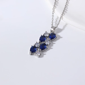 Silver necklace featuring leaf-shaped blue sapphires and white cubic zirconia cluster
