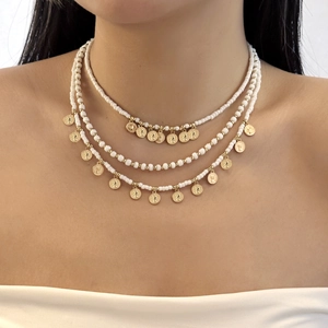 Détail du collier de perles à trois couches avec pendentifs de pièces d'or rétro