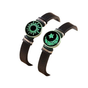 Detail showing glowing sun and moon glass charms on black woven couple bracelets