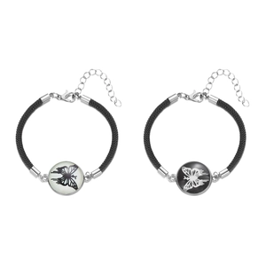 Macro detail of hand-woven butterfly charm bracelets with polished lobster clasp and chain